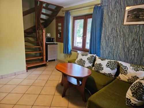 a living room with a green couch and a wooden table at Nad Potokiem in Kaczorów