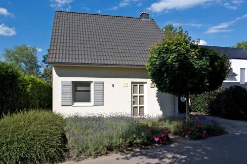 una casa blanca con techo negro en Ferienhaus Ahorn, en Göhren-Lebbin