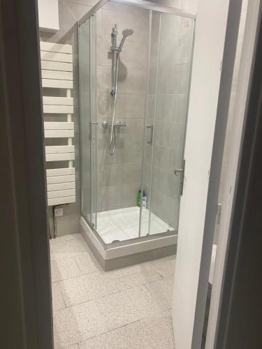 a shower with a glass door in a bathroom at Warm and fully equipped studio in Aubervilliers