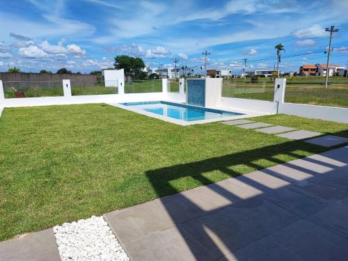 a pool in the middle of a grass field at Arena cielo y Mar in Santa Cruz de la Sierra