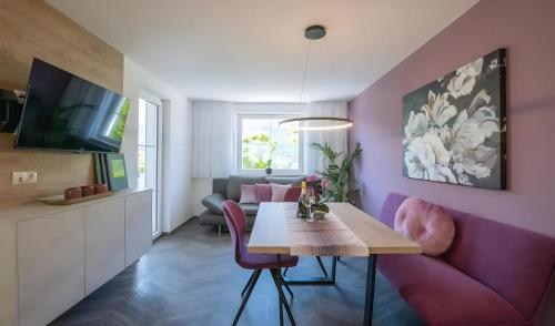 a living room with a purple couch and a table at Gartenhof in Brixen