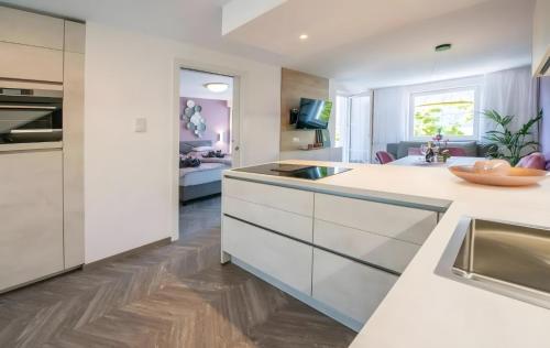 a kitchen with white cabinets and a living room at Gartenhof in Brixen