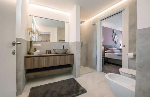 a bathroom with a sink and a toilet and a bed at Gartenhof in Brixen