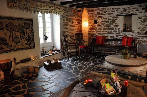 un salon avec un mur en pierre et une chambre avec une table dans l'établissement Les Chambres du Moulin, à Susmiou