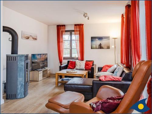 a living room with a couch and a tv at Haus Hornhecht in Kamminke