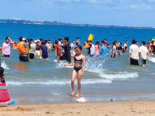 a young girl in a bikini standing on the beach at Gold Stars Hotel in Long Hai
