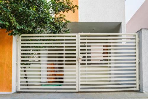 a white gate in front of a building at Super Hotel O Neelbad Guest House in Bhopal