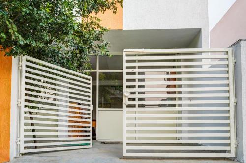 two white gates in front of a building at Super Hotel O Neelbad Guest House in Bhopal