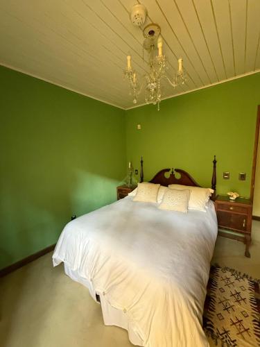 a bedroom with a white bed in a green wall at Neike Hotel Boutique in Punta del Este
