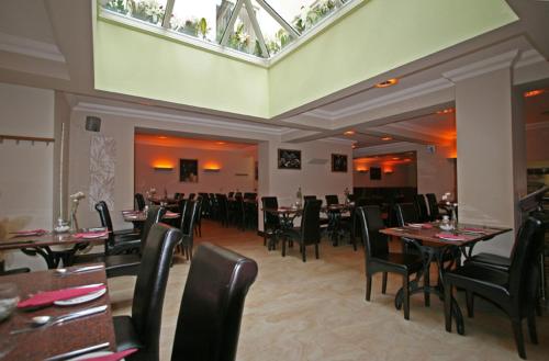 un comedor con mesas y sillas en un restaurante en York House Hotel, en Wakefield