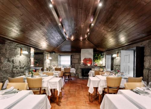 a dining room with white tables and chairs at Casa de Louredo in Paredes