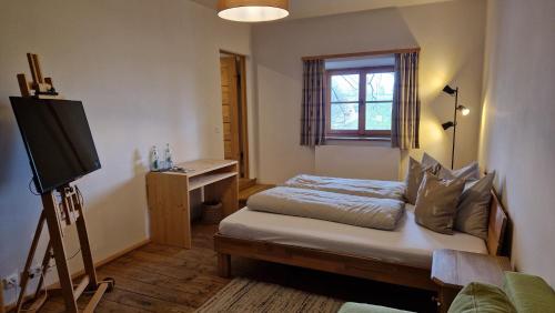 a bedroom with a bed and a television in it at Hotel Landgasthof Alter Wirt in Fischbachau