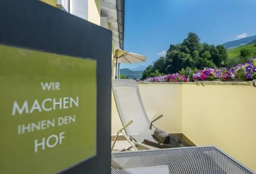 a sign in front of a chair on a balcony at Gartenhof in Brixen