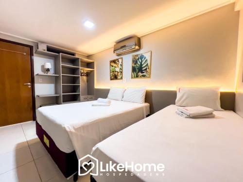 two beds sitting next to each other in a room at Manaíra Palace, Beira Mar - LikeHome Hospedagens in Tambaú