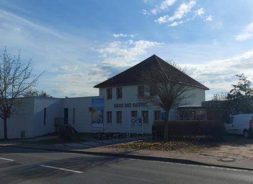 a white building with a black roof on a street at Moderne Ferienwohnung "Parkblick" im Ostseebad Ückeritz in Ueckeritz