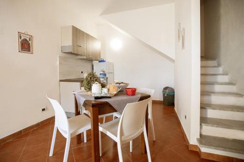 a dining room with a table and white chairs at Casa Atena in Motta D'affermo