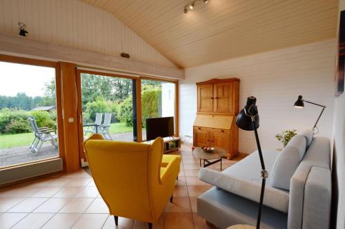 una sala de estar con un sofá y una silla en Haus Bergliebe, en Prien am Chiemsee