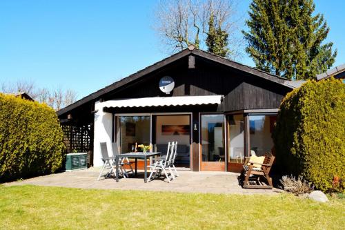 una casa con un patio con sillas y una mesa en Haus Bergliebe, en Prien am Chiemsee