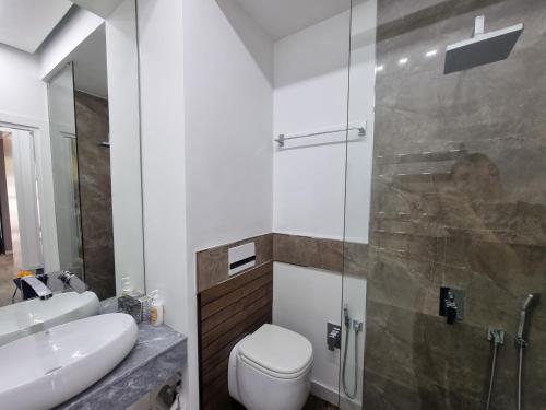 a bathroom with a toilet and a glass shower at Premium Apartment by Bakuapart in Baku