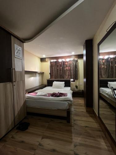 a bedroom with a large bed and a mirror at Hotel Oak in Namchi