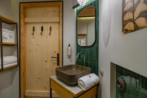 a bathroom with a sink and a mirror and a door at Leśniczówka u Zięby in Kościelisko