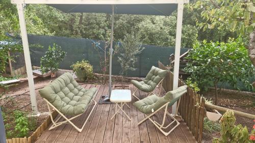 un patio avec deux chaises et un parasol dans l'établissement Studio calme avec jardinet, à Fréjus