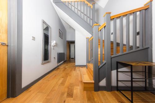 a hallway with wood floors and stairs at Luxury Seaview Cottage by Fairy Pools 2 in Carbost