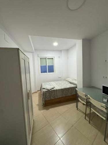 a bedroom with a bed and a desk and a window at TourismCasa in Dos Hermanas