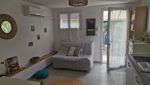 un salon avec un canapé et une cuisine dans l'établissement Studio calme avec jardinet, à Fréjus