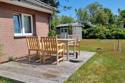 ein Holztisch und Stühle auf einer Holzterrasse in der Unterkunft Deelswai 50, Bungalow in Goting