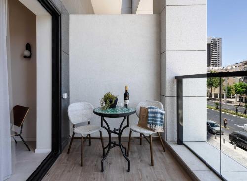 a table on a balcony with a bottle of wine at Tayo Studios & Apartments in Bat Yam