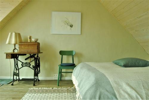 a bedroom with a bed and a table and a chair at Ferien am Roten Haus in Buckow