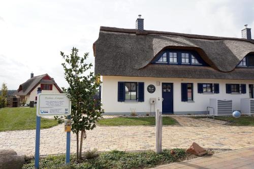 a thatched house with a sign in front of it at Reethaus "Calappa" in Zierow