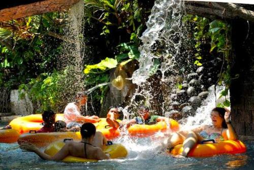 a group of people in the water at a waterfall at ABI Hotel2 - 1 minute to the Beach and 1 second to the Mall in Ngurah Rai International Airport