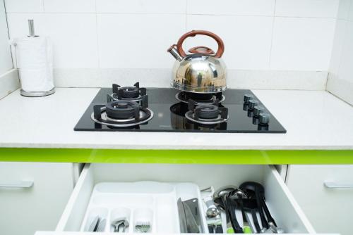 a tea kettle sitting on top of a stove in a kitchen at Suit 360 Abuja in Abuja