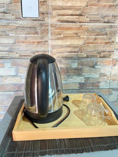 a tea kettle sitting on a tray on a table at ABI Hotel2 - 1 minute to the Beach and 1 second to the Mall in Ngurah Rai International Airport