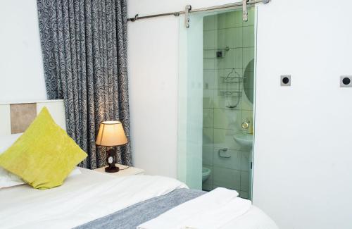 a bedroom with a bed and a shower at Suit 360 Abuja in Abuja