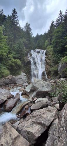a waterfall on the side of a river with rocks at Wuthering Heights in Angolo Terme