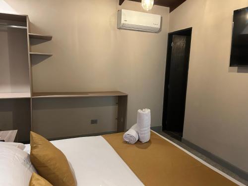 a bedroom with a bed and a tv on a wall at Casa Kyros Boutique in Medellín