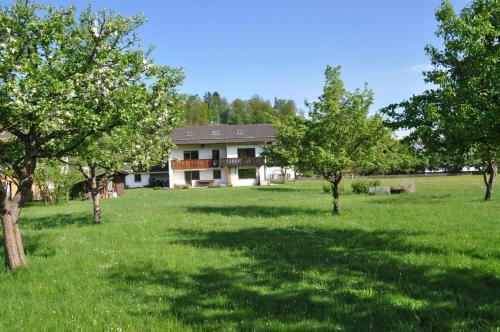 una casa en medio de un campo con árboles en Alpenzauber, en Bernau am Chiemsee