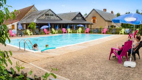 una piscina con una mujer y un niño sentado en sillas en Camping Valloire-sur-Cisse, en Seillac