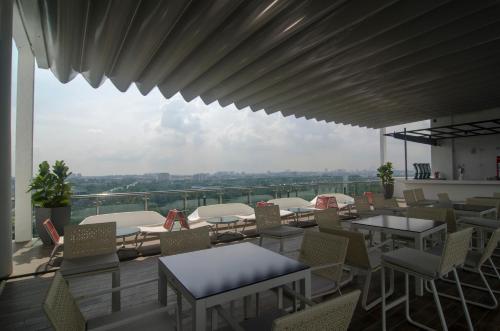 a balcony with tables and chairs and a view of the city at Amerin Hotel Johor Bahru in Johor Bahru