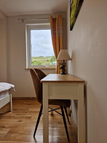 a room with a desk and a window with a table and chairs at Luxury Cottage by Fairy Pools 4 in Carbost