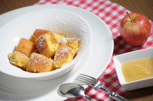 a bowl of food on a plate with an apple at Alpenhotel DAS KÜREN in Hirschegg