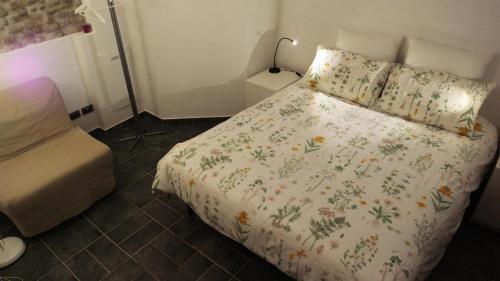 a small bedroom with a bed with a floral bedspread at All' Ombra del Portico in Bologna