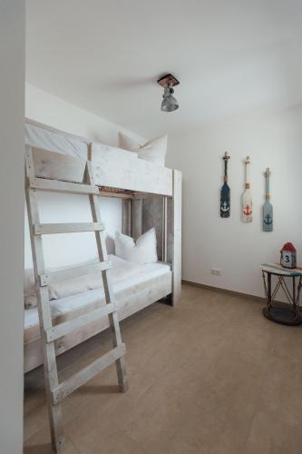 a white bunk bed with a ladder in a room at Exklusive Ferienwohnungen an der Havel in Werder