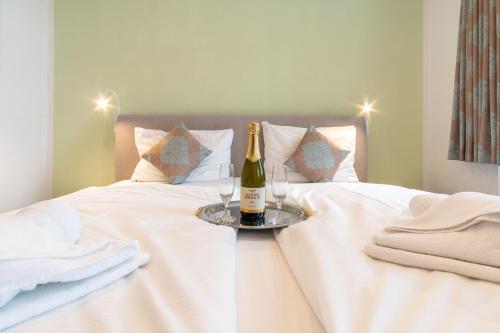 a bottle of champagne and two glasses on a bed at Ferienwohnung 13 Villa Eden in Binz