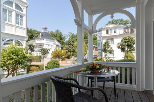 a porch with two chairs and a table with flowers on it at Ferienwohnung 13 Villa Eden in Binz