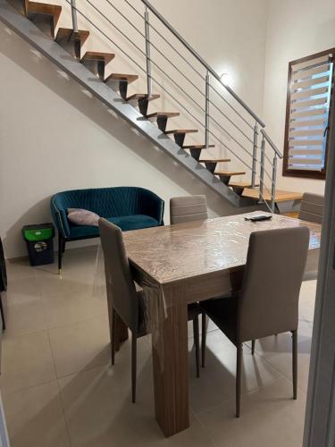 a dining room with a table and chairs and stairs at Sole di Sicilia in Locogrande