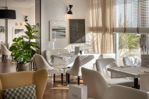 a restaurant with white tables and white chairs at Excelsior Hotel, SPA & Lido - Preferred Hotels & Resorts in Pesaro